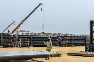 Workers laying out pipes for installation at an oil site run by TotalEnergies in Tilenga, Uganda on Jan. 16, 2023. (Arlette Bashizi/The New York Times)